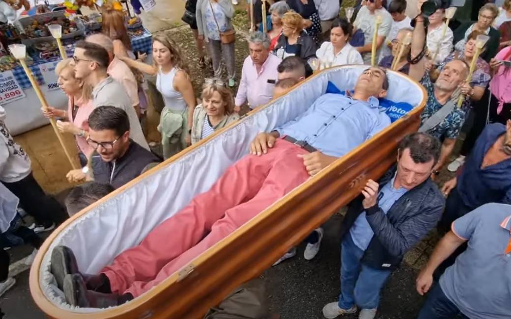 Het traditionele bijna-doden feest en het levend in doodskisten ronddragen in Galicië